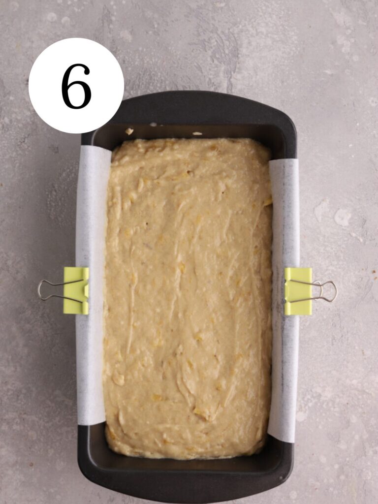 A loaf pan with banana bread batter in it.