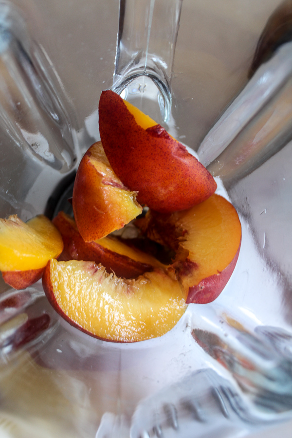 overhead view of of chopped peach slices in a blender