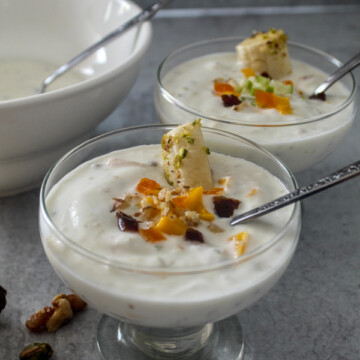 two dishes of plain yogurt with chopped fruit and nuts on top