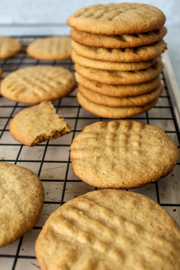 A stack of freshly made old fashioned peanut butter cookies on a rack.