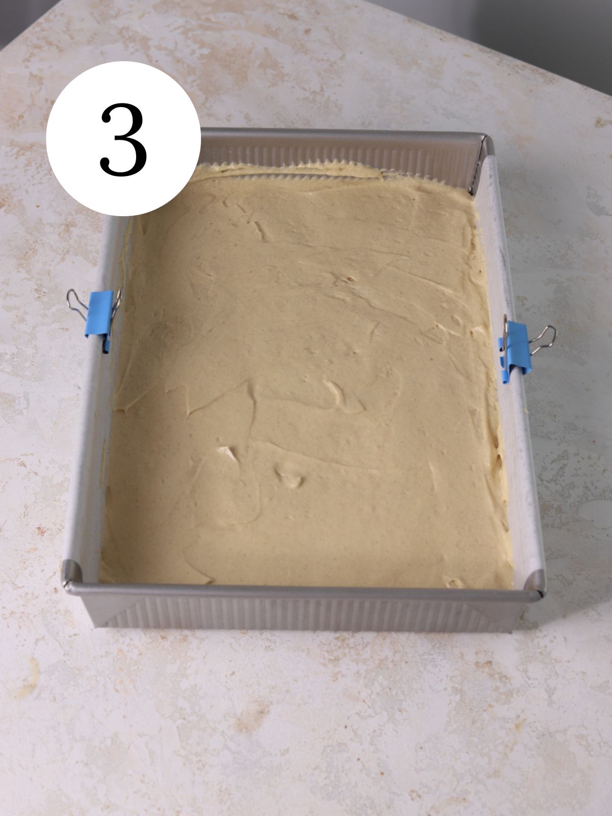 A rectangular pan filled with cake batter. 