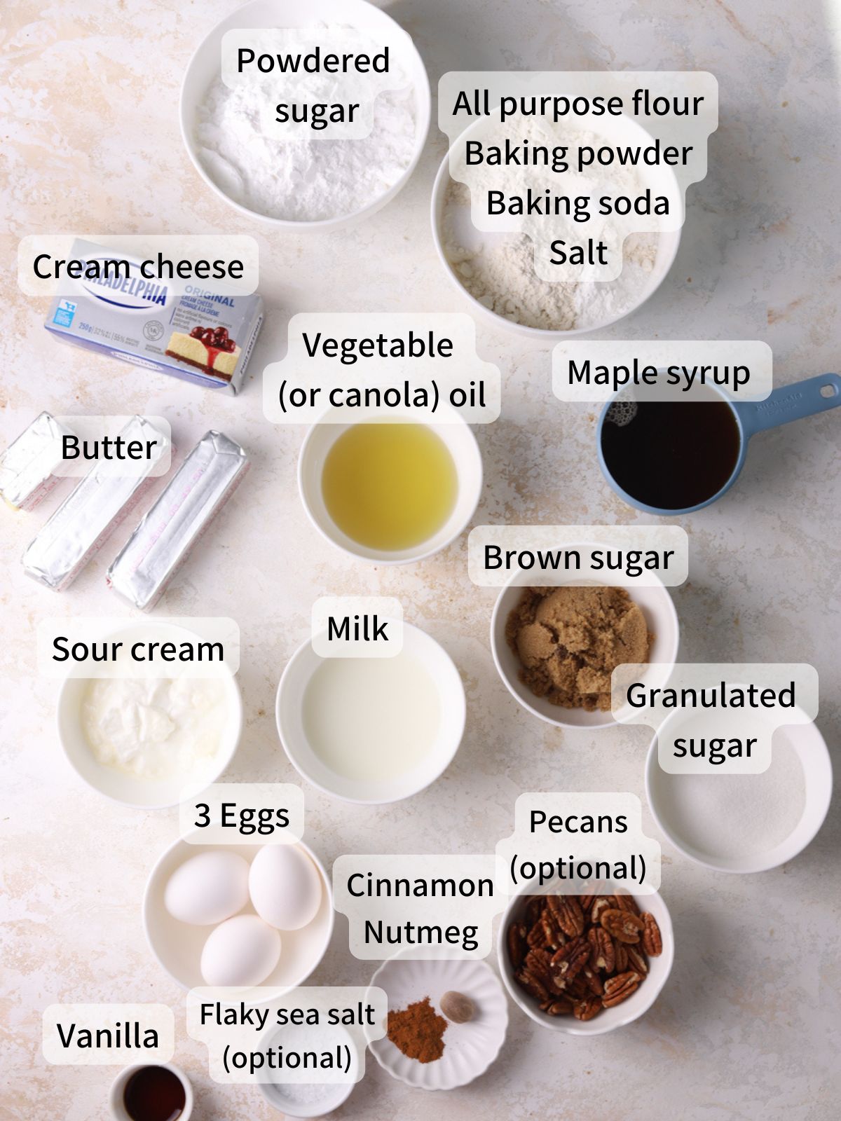 Labeled ingredients needed to make maple cake laid out on a table. 