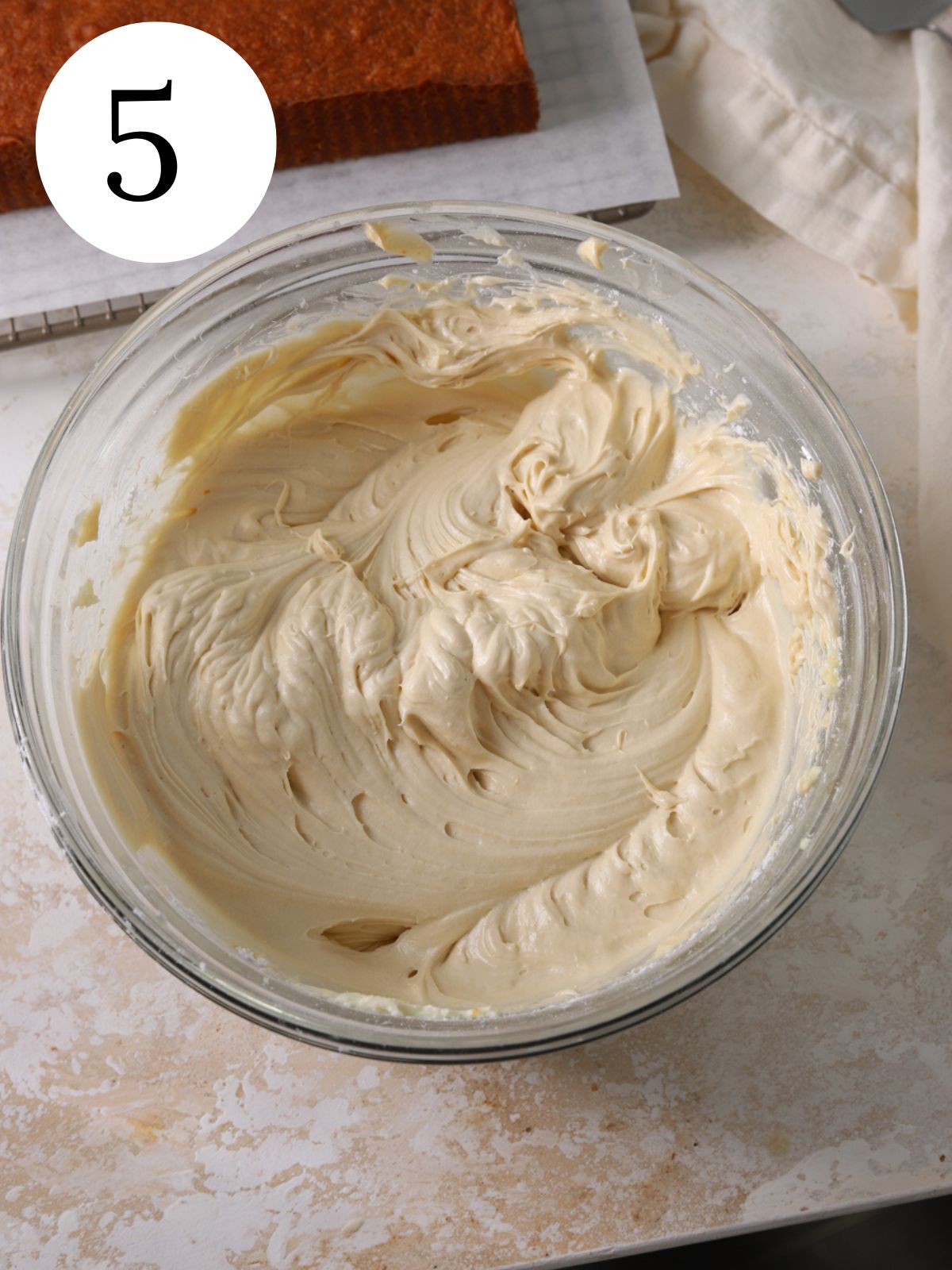 A large glass bowl with maple cream cheese frosting.