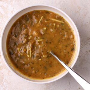 A bowl of Moroccan harira soup with a spoon in it.