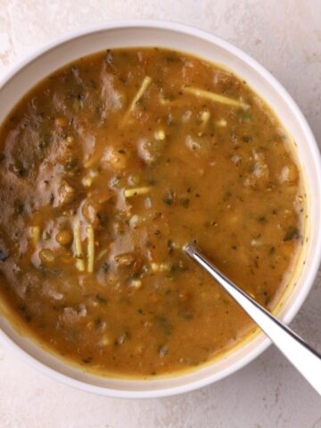 A bowl of Moroccan harira soup with a spoon in it.