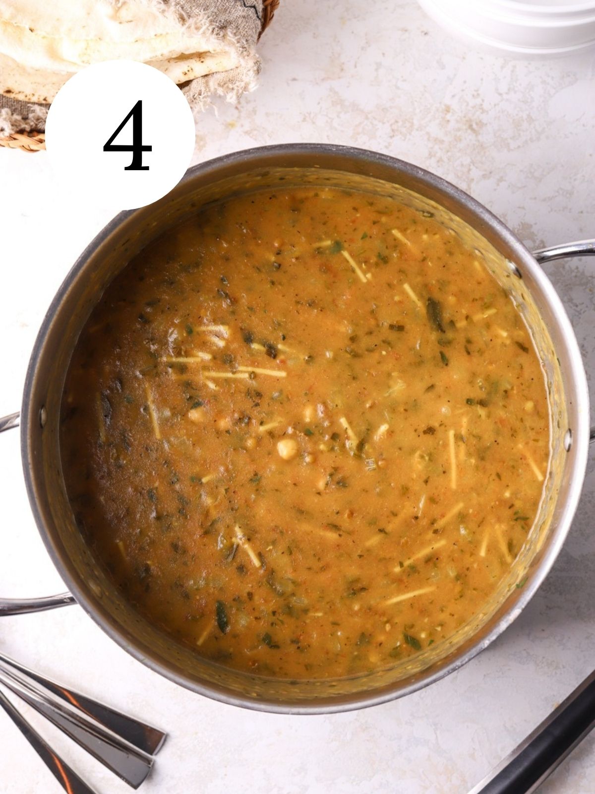 A soup pot filled with tomato and chickpea harira soup. 