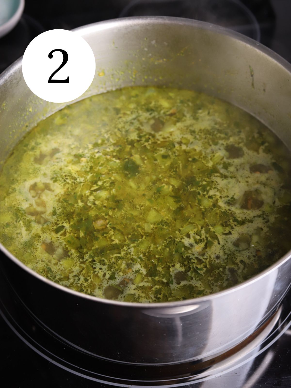 A large soup pot with an herby broth for making harira soup.