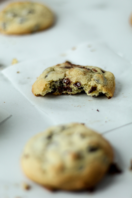 A chocolate chip cookie loaded with a bite revealing melted chocolate chips.