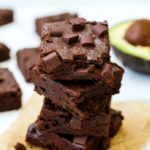Delicious chocolatey avocado brownies with chocolate chunks in a stack.