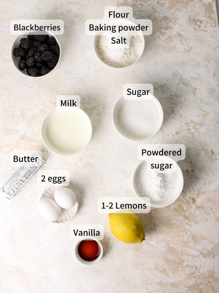 Labeled ingredients needed to make blackberry cupcakes laid out on a table.