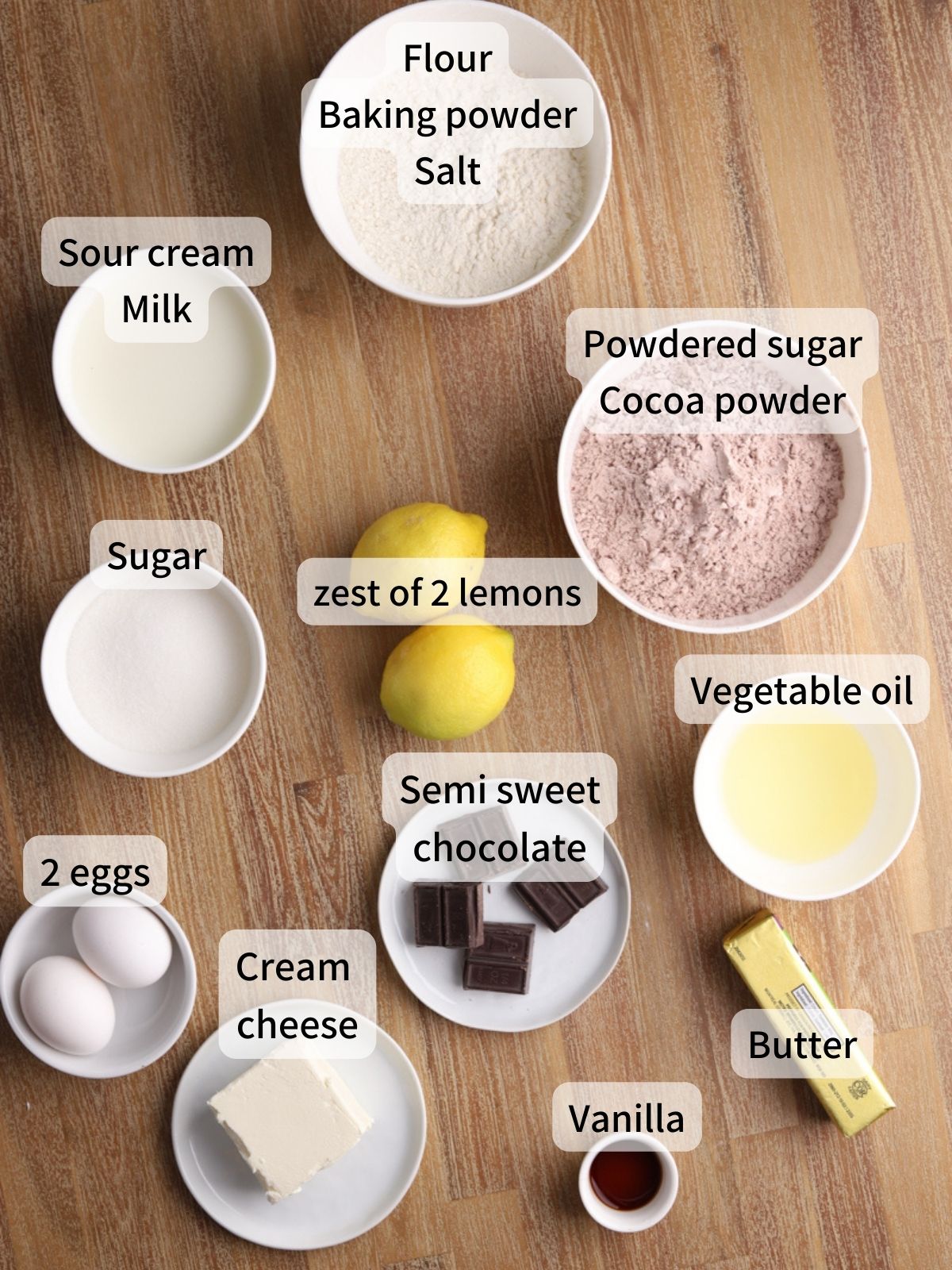 Labeled ingredients needed to make lemon chocolate cake laid out on a table.