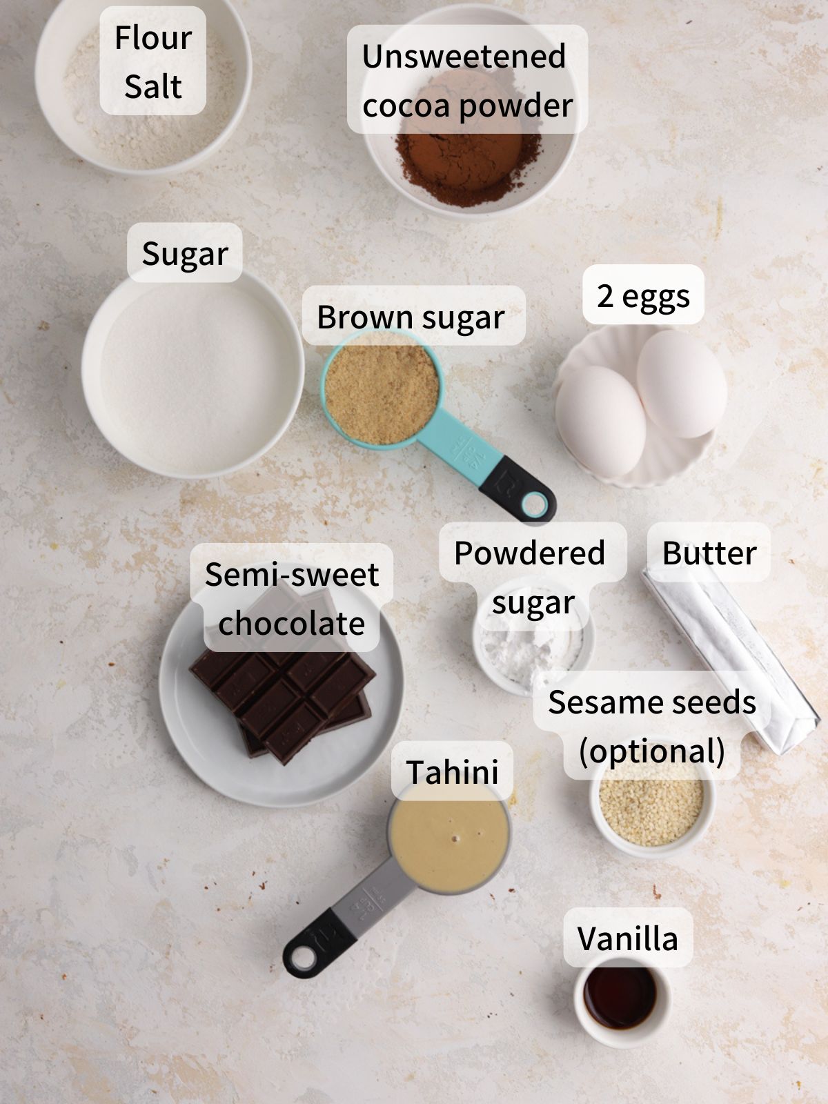 Labeled ingredients needed to make tahini brownies laid out on a table.