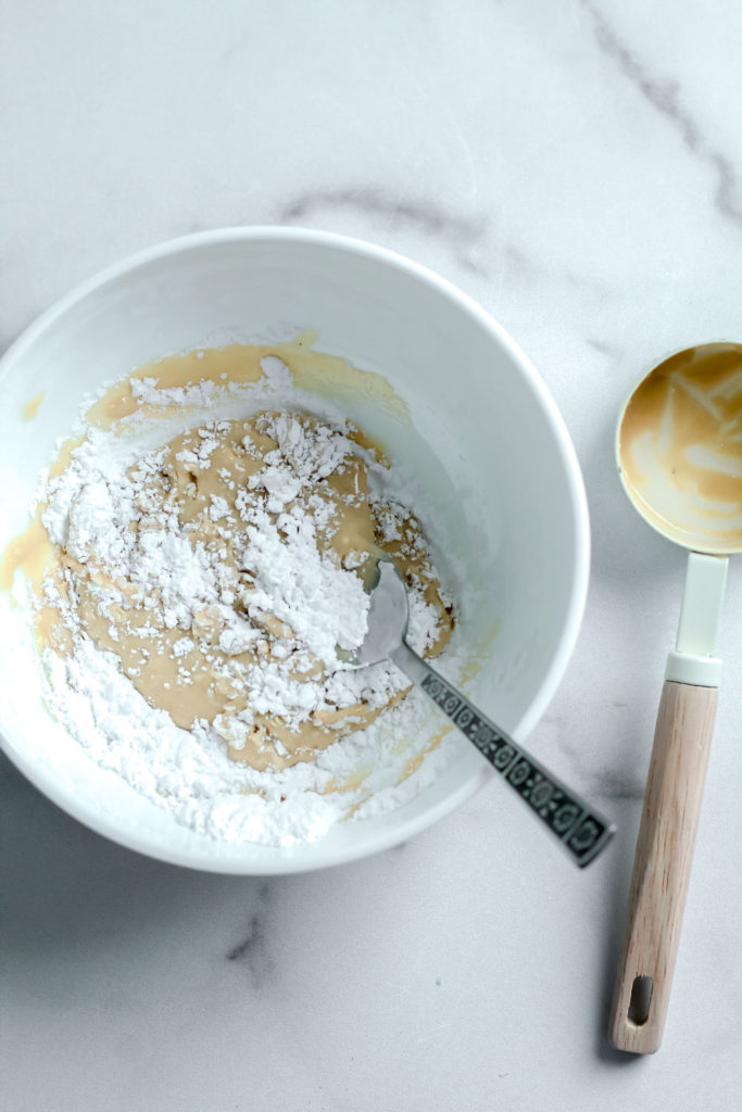 Tahini and powdered sugar being stirred together.