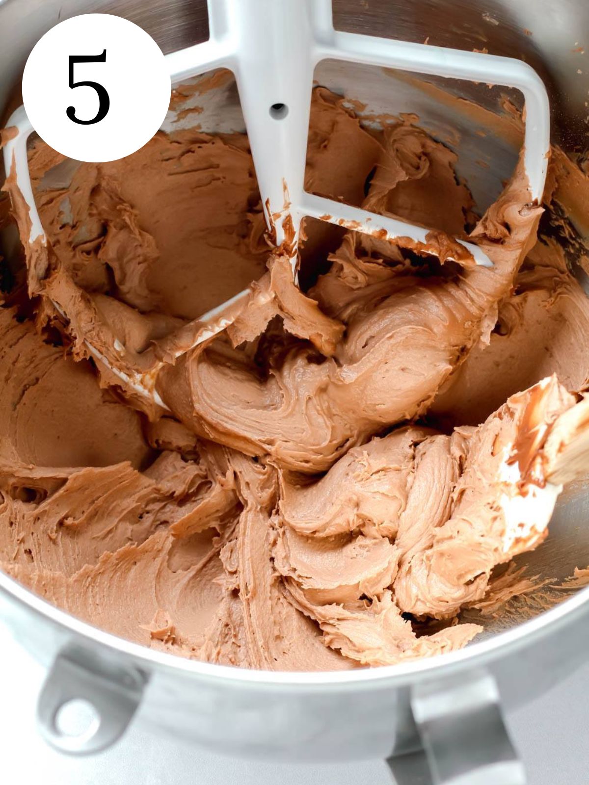 A bowl of an electric mixer with nutella frosting.