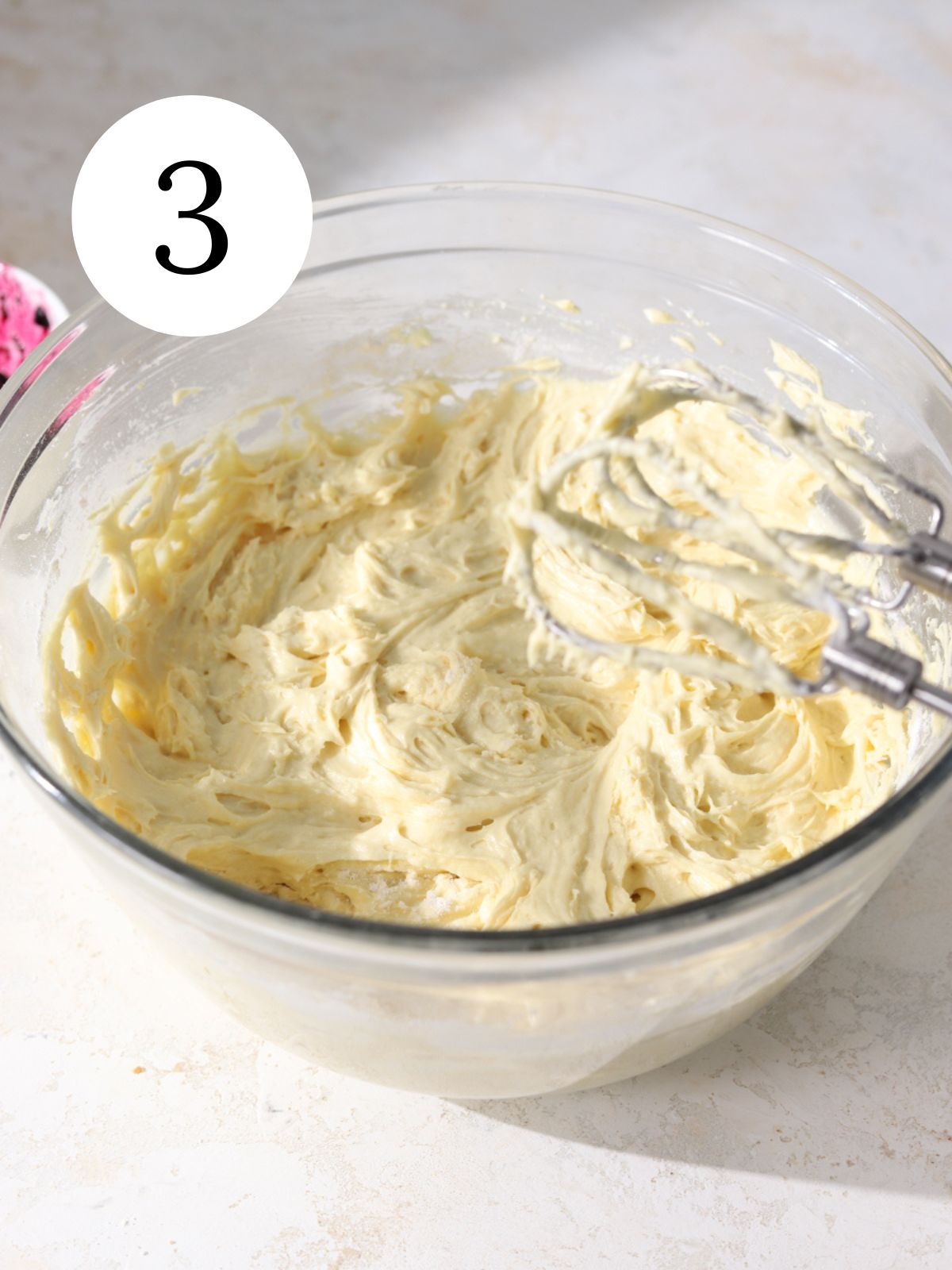 A large mixing bowl with cake batter and a mixer.