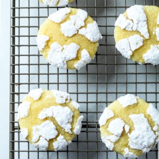 powdered covered lemon cookies on a rack