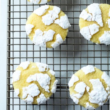 powdered covered lemon cookies on a rack