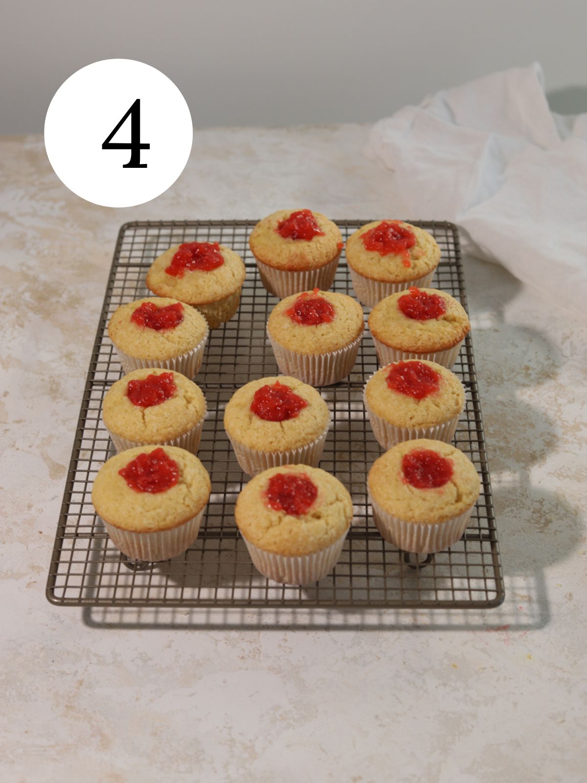 Strawberry filled cupcakes on a wire rack.
