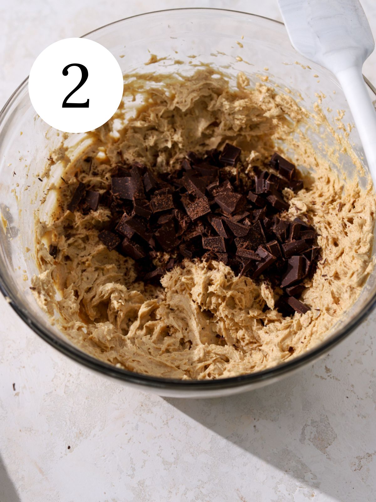 Choppped chocolate in a bowl with peanut butter cookie dough.
