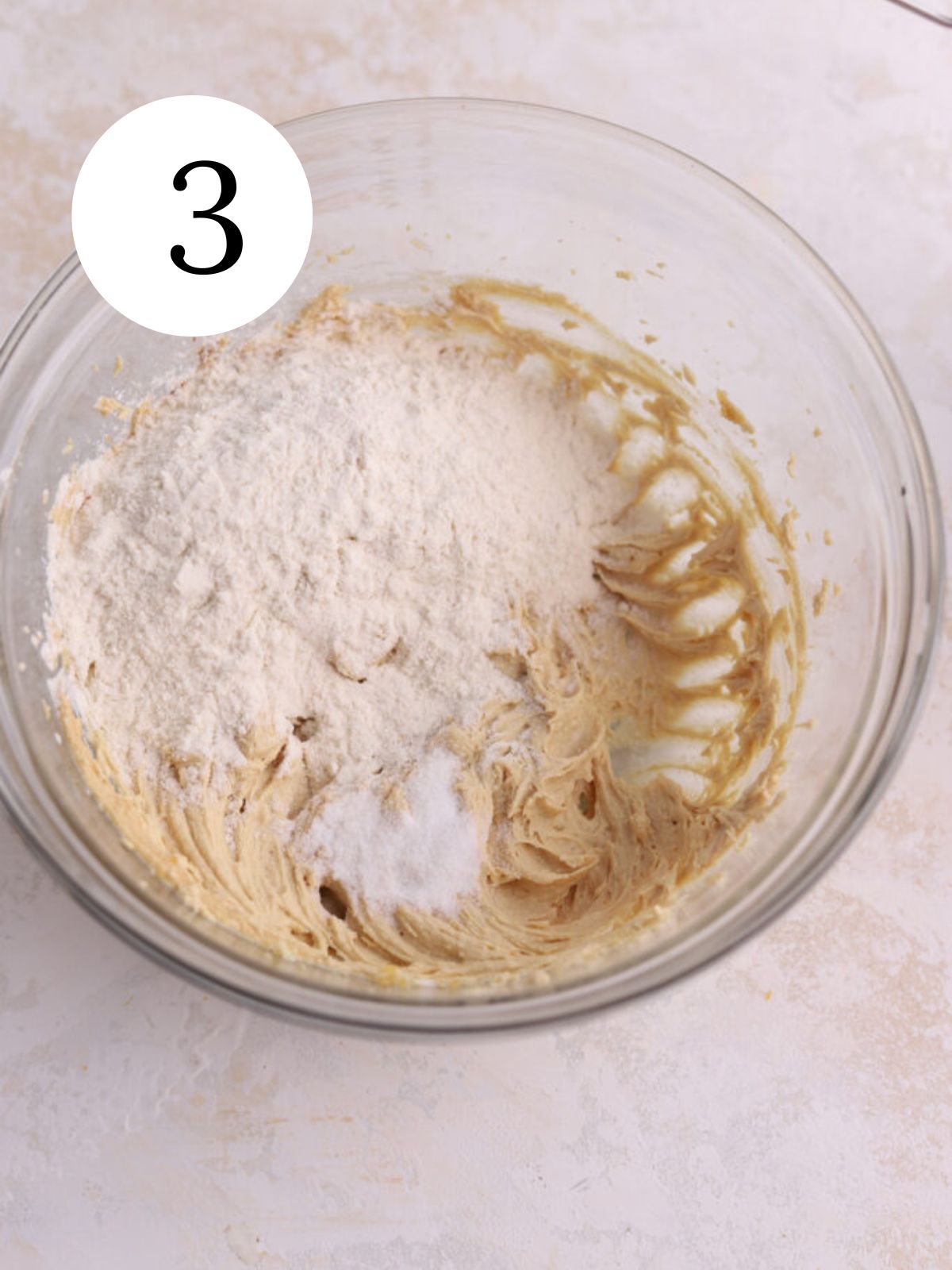 A mixing bowl with flour added to peanut butter cookie dough.