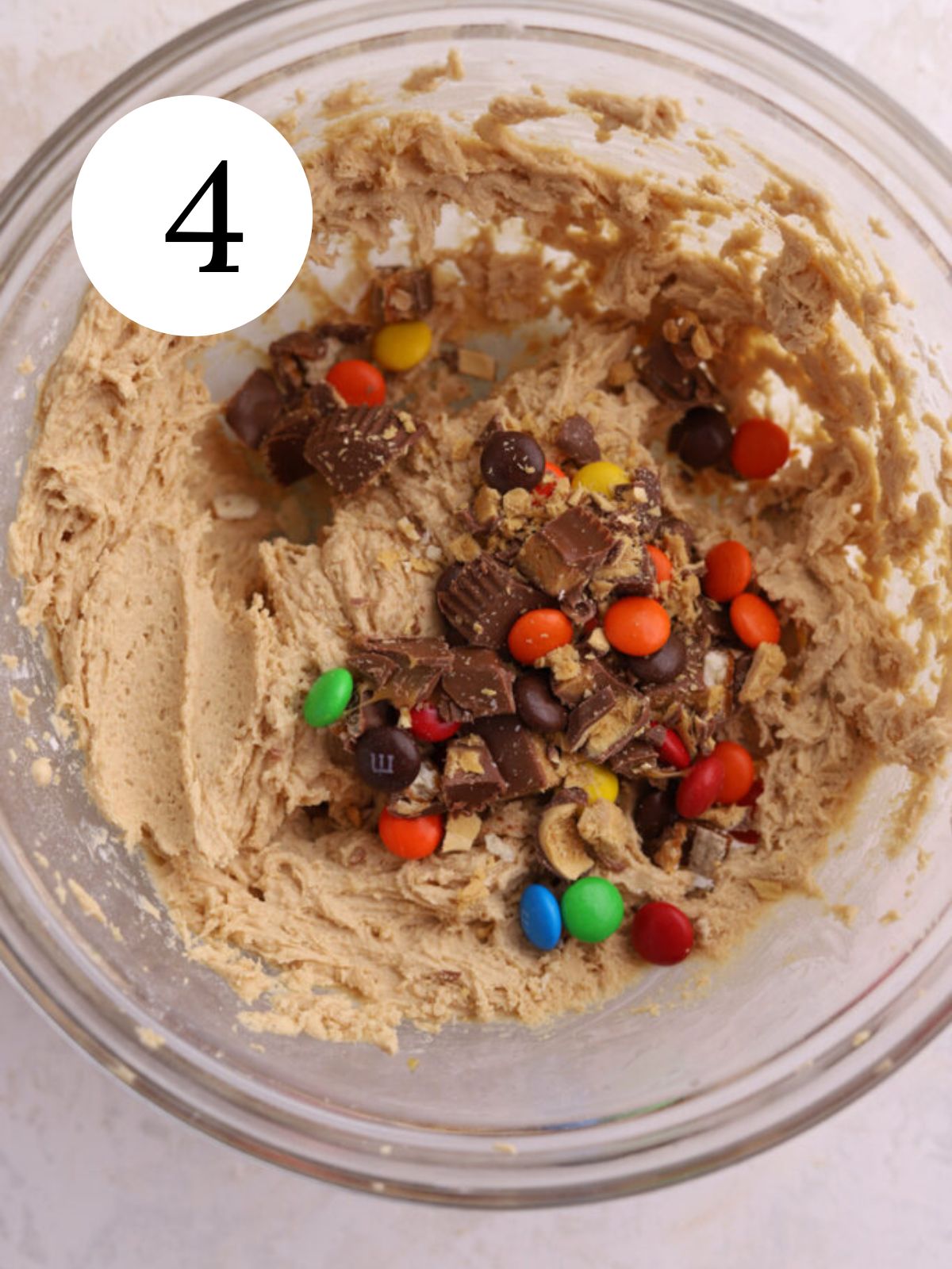 A bowl with chocolate candy added to peanut butter cookie dough.