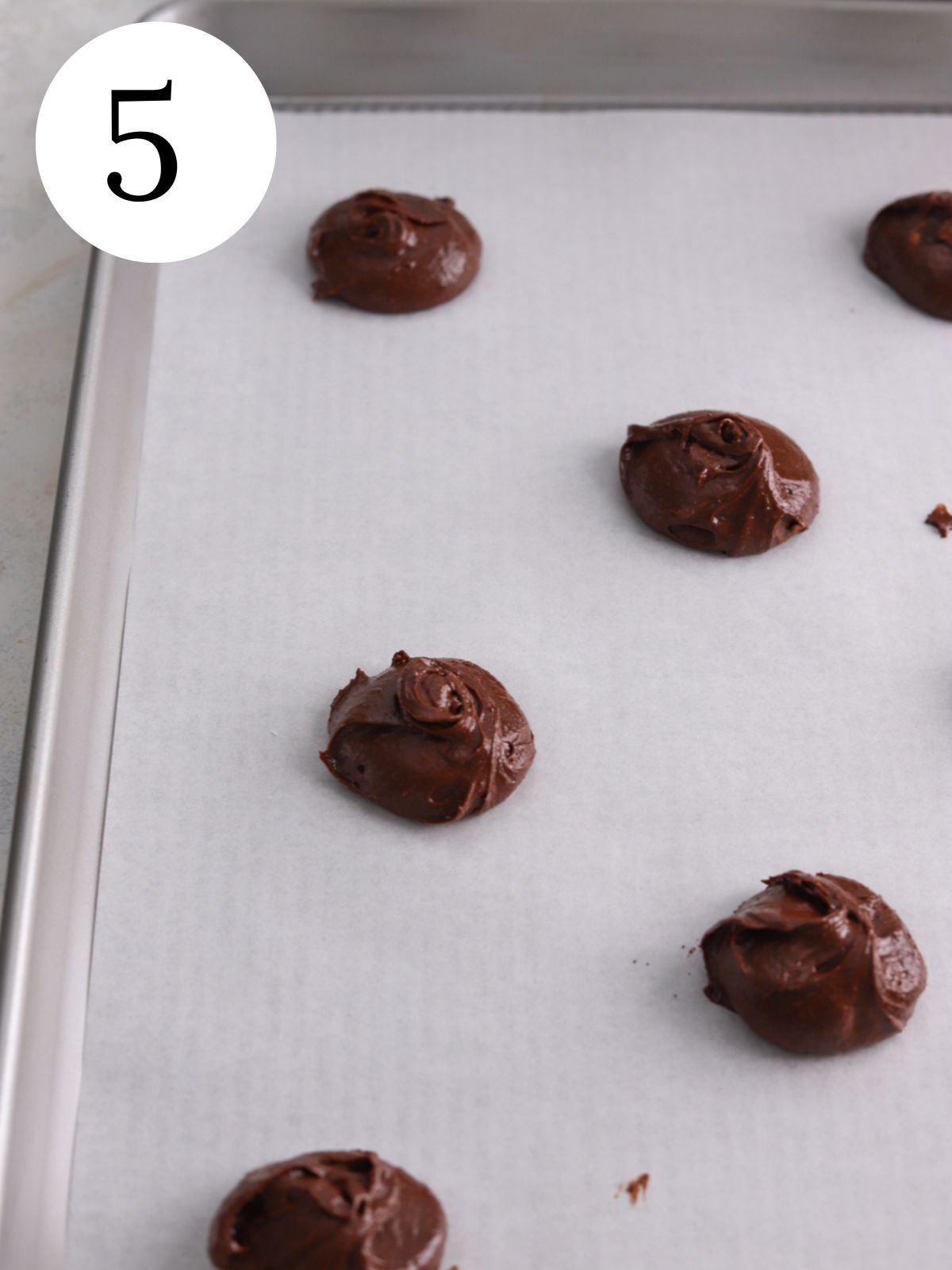 Chocolate cookie dough balls on a baking sheet. 