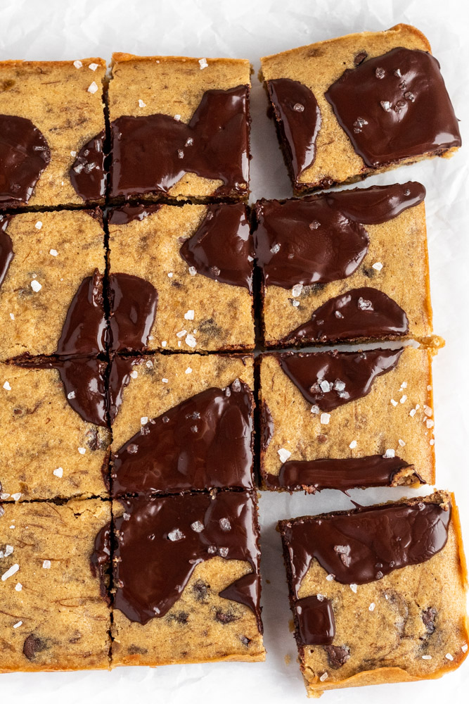 Banana blondies cut into squares with sea salt and chocolate melted on top.