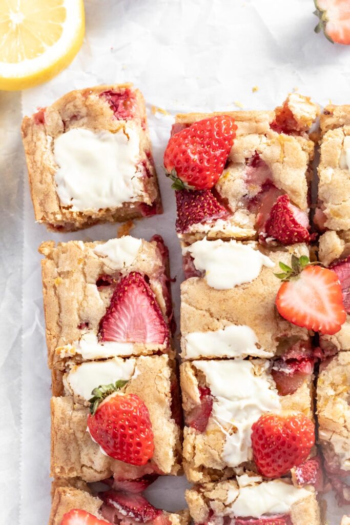 Blondie brownies with slices of strawberries baked on top and pools of melted white chocolate. 