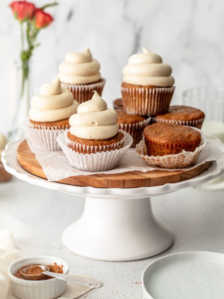 Frosted carrot cupcakes on a cake stand. 