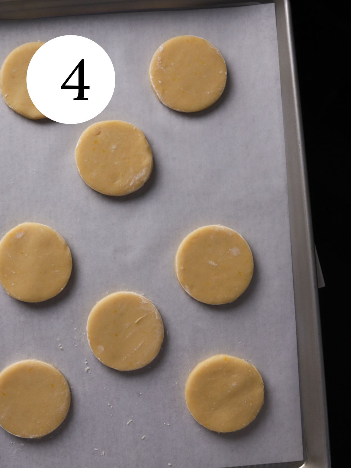 Cut out circular cookies on a baking sheet lined with parchment paper.