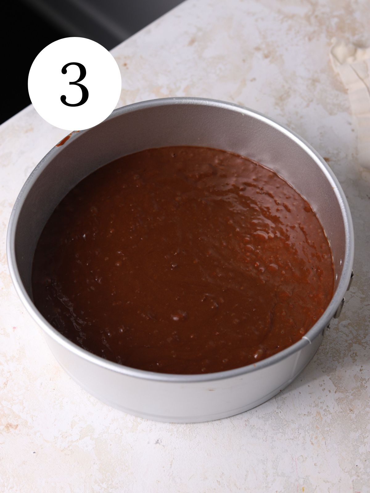 Nutella chocolate cake batter in a round springform pan.