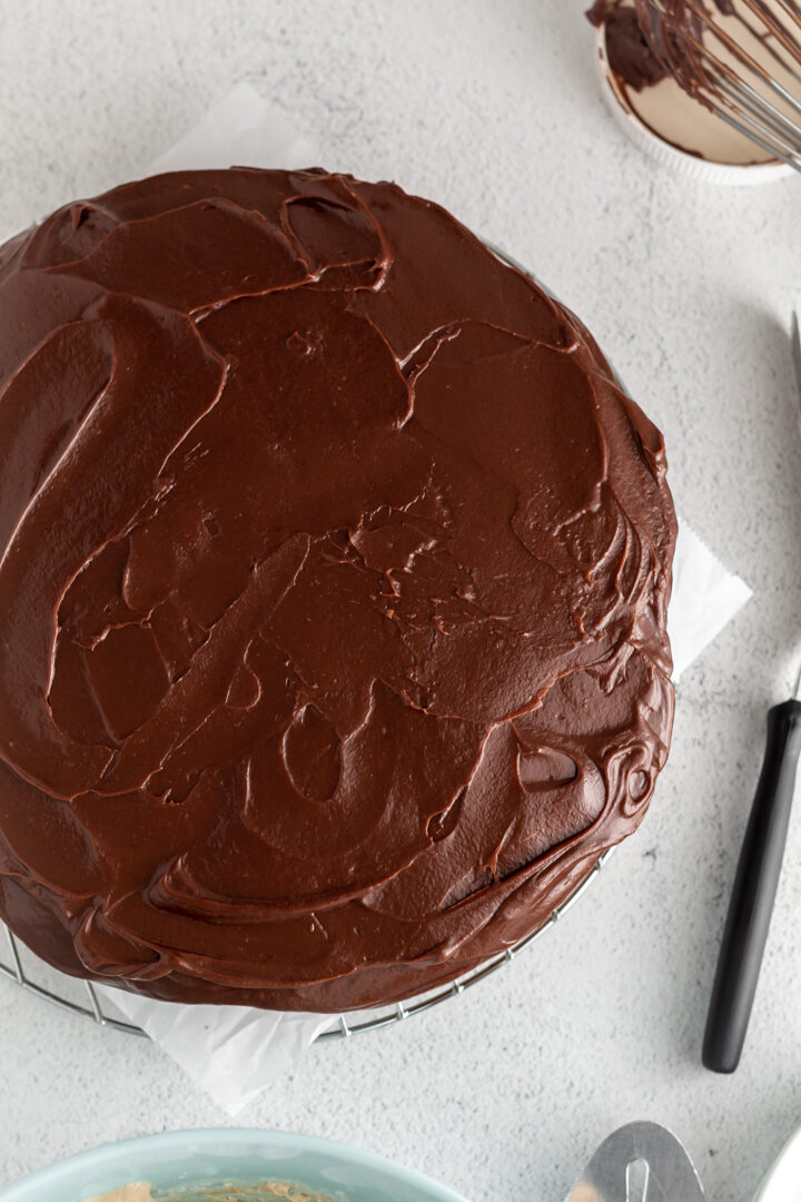 A close up of swirls of chocolate ganache with an offset spatula nearby. 