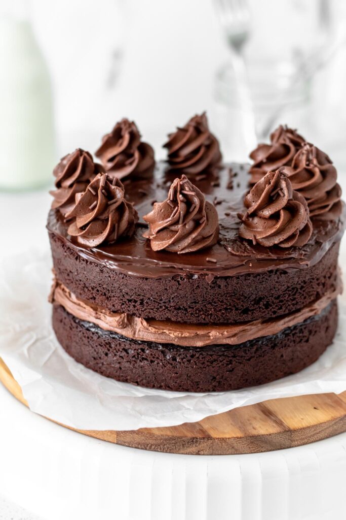 A two layer chocolate cake with chocolate frosting in the middle and on top. 