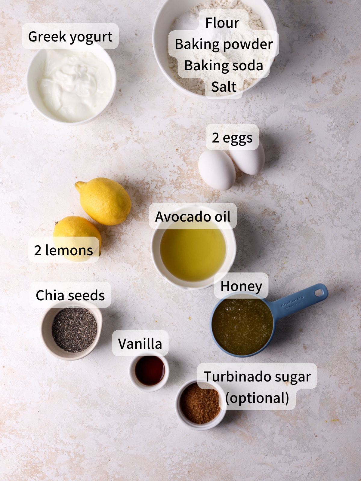 Labeled ingredients needed to make lemon chia seed muffins laid out on a table. 