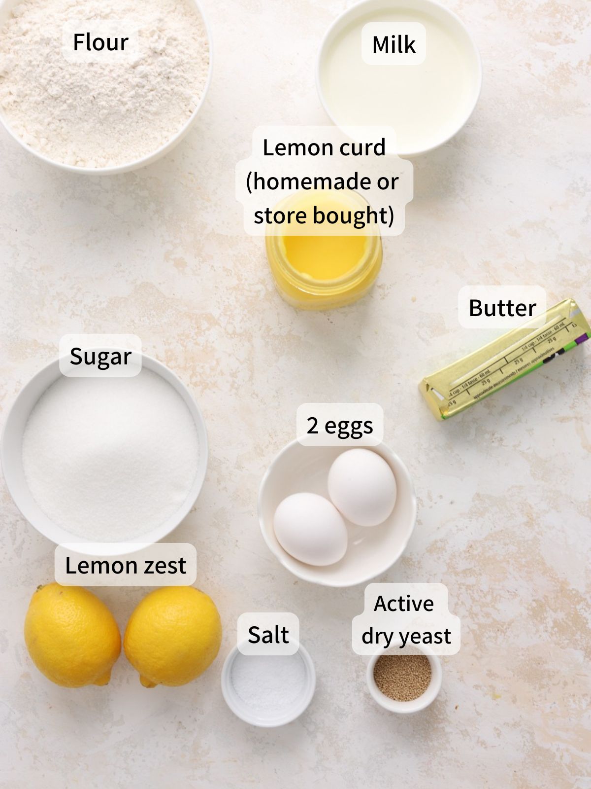 Labeled ingredients needed to make lemon filled donuts laid out on a table.