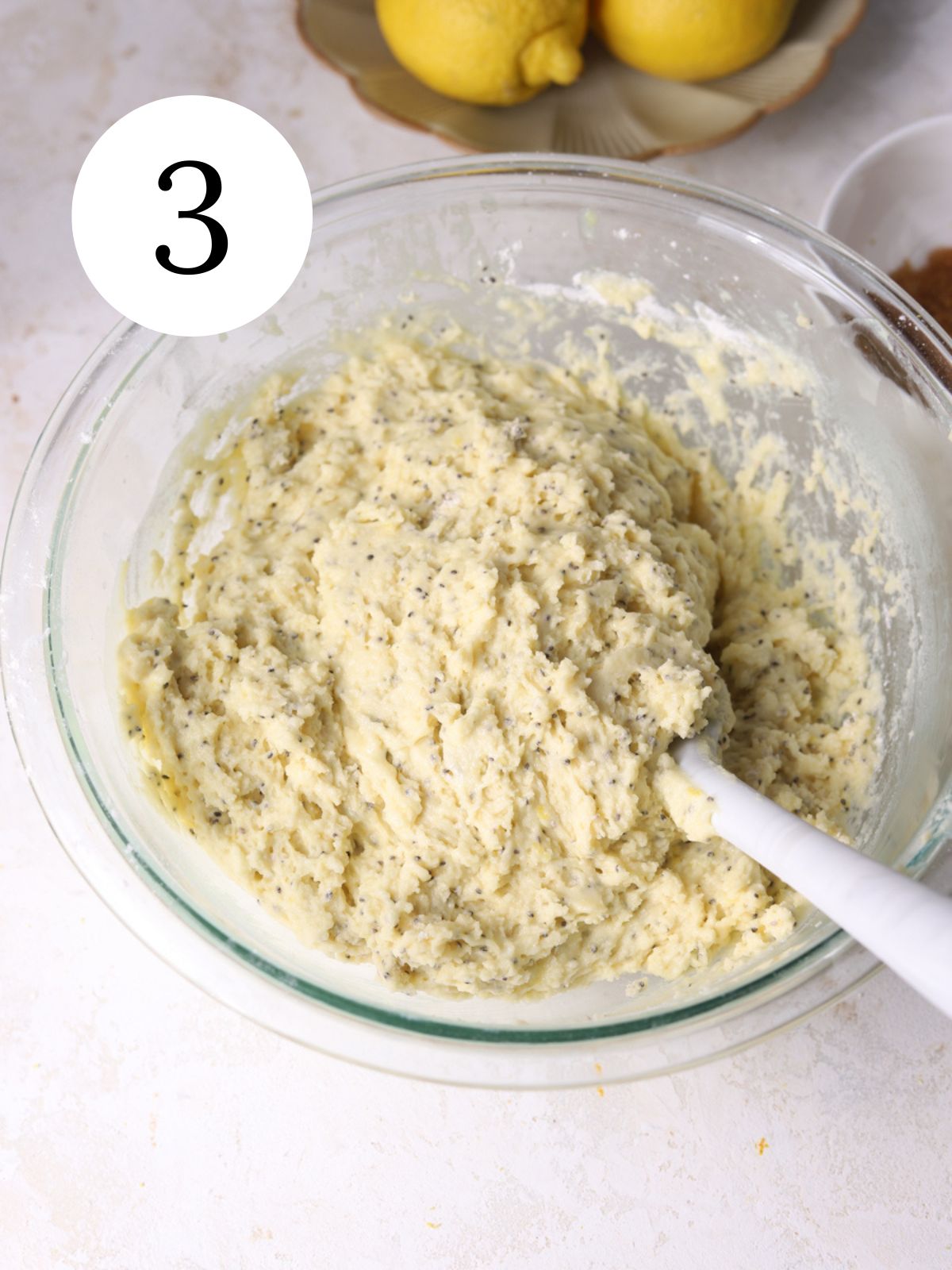 Muffin batter being mixed together in a bowl with a spatula in it. 