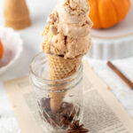 Pumpkin pie ice cream in a cone and a mini pumpkin.