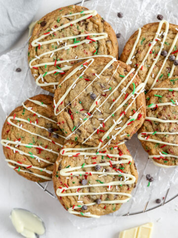 Big cookies with Christmas sprinkles and chocolate chips and white chocolate on top.