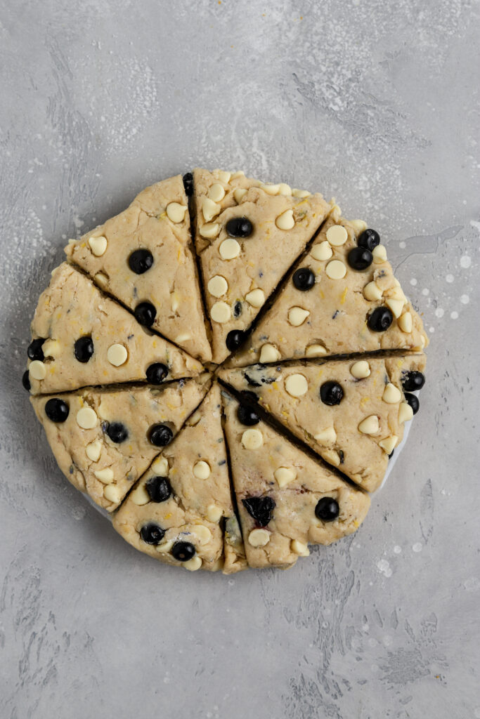 Scone dough filled with blueberries sliced into triangles.