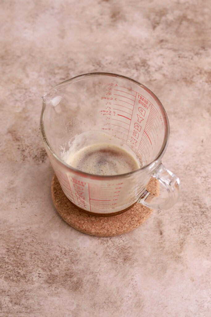 A glass measuring cup with browned butter in it.