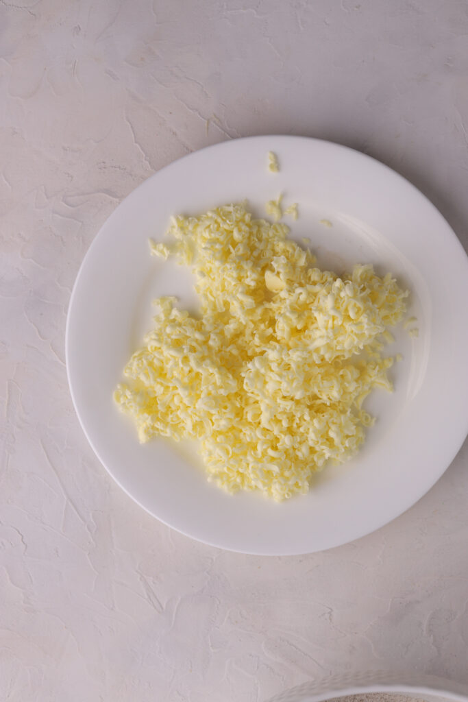 A white plate with shredded butter on it.