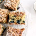 Pieces of banana blueberry coffee cake on a cooling rack.