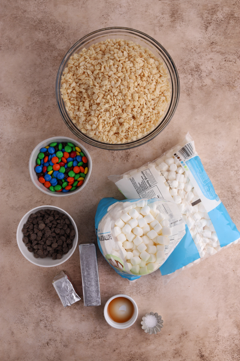 Bowls of Rice Krispies, M&Ms, chocolate chips, butter, and bags of mini marshmallows. 