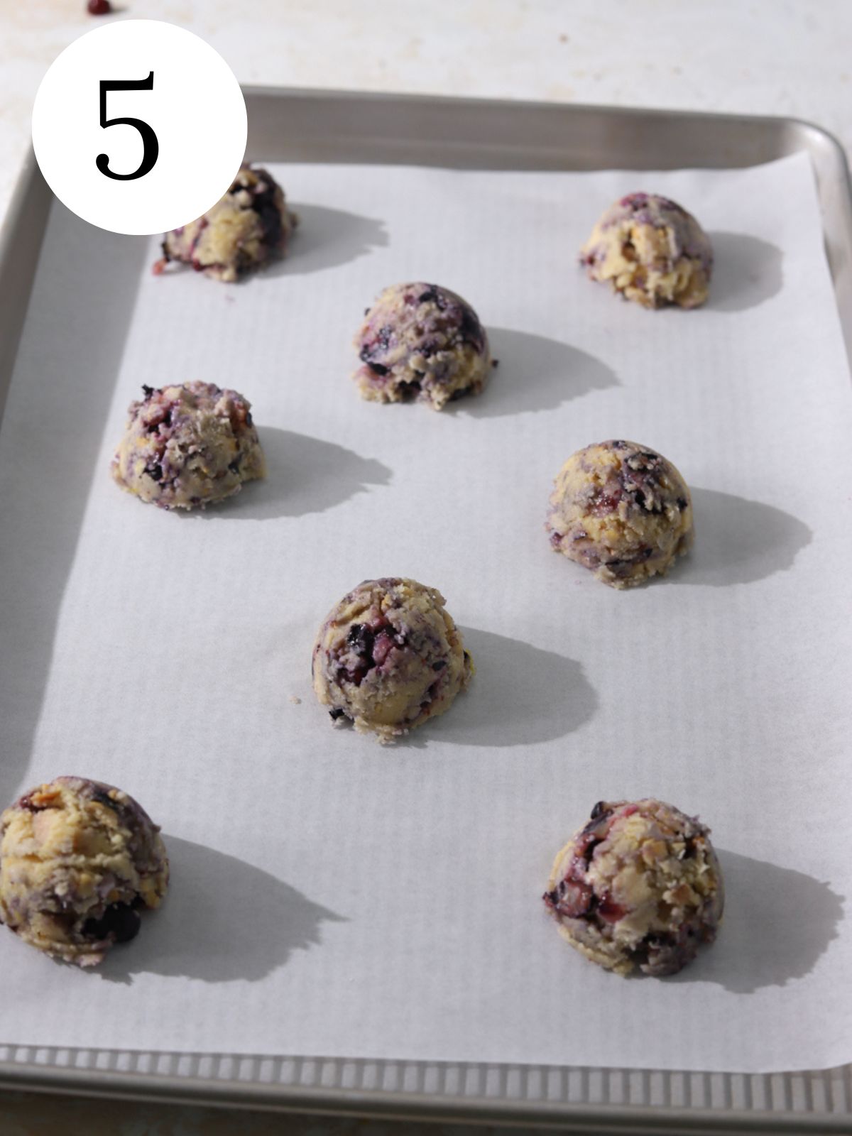 Blueberry cookie dough balls on a baking sheet. 