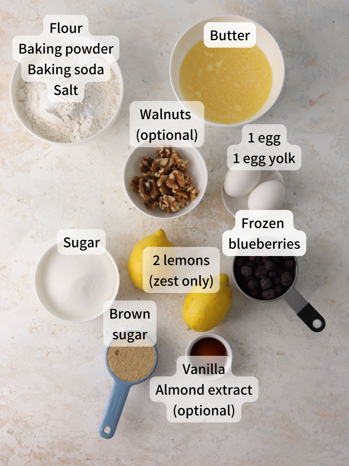 Labeled ingredients needed to make lemon blueberry cookies laid out on a table.