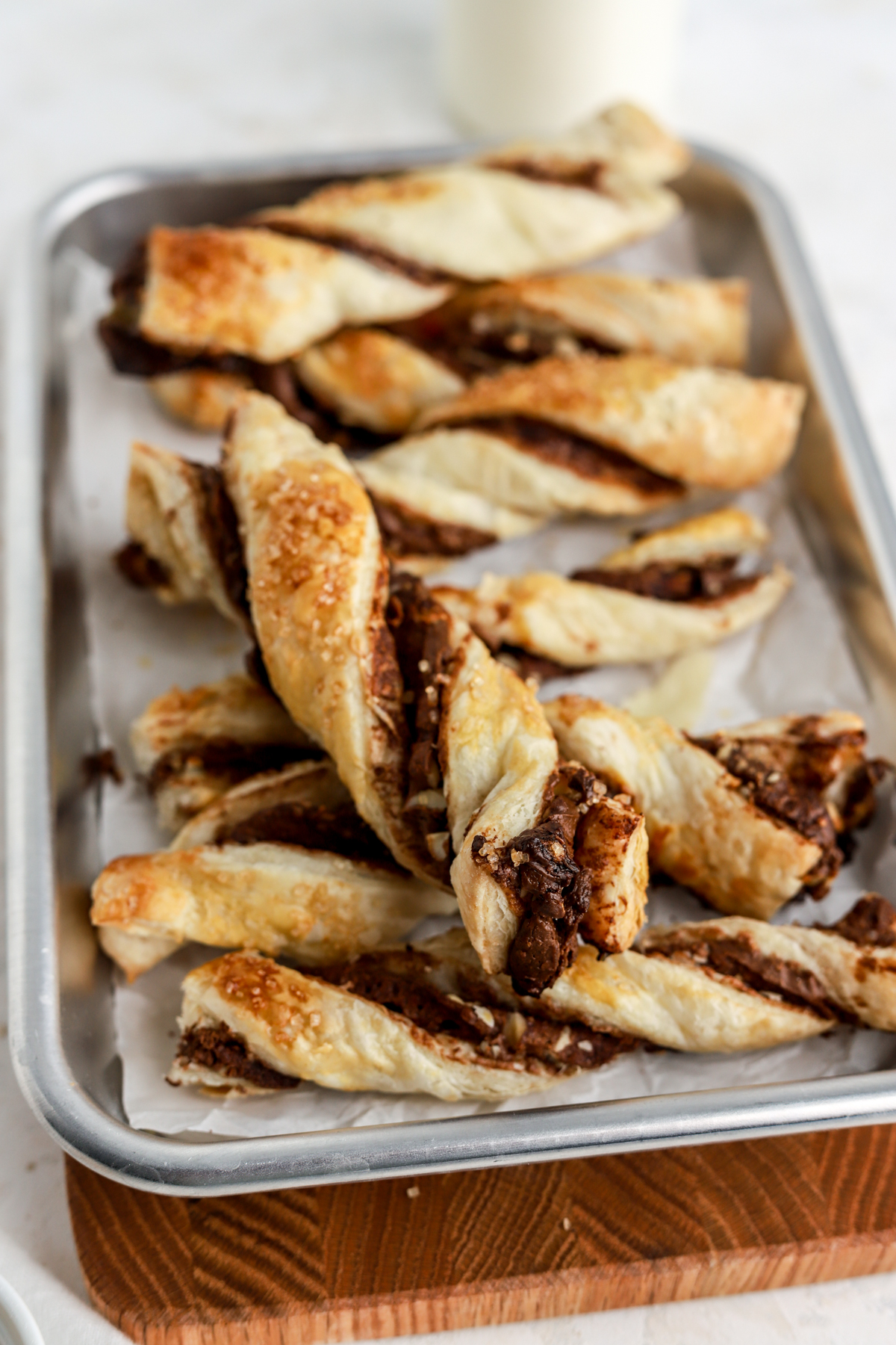 Puff pastry twists filled with chocolate on a small baking tray.