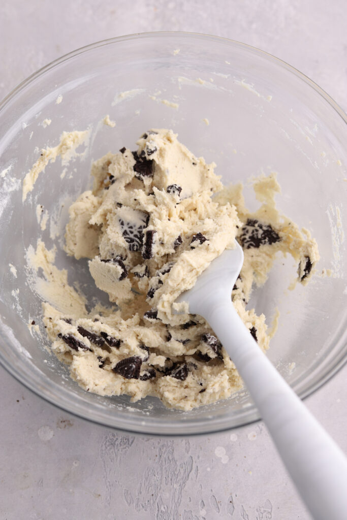 Oreo cookie dough in a mixing bowl with a spatula in it. 