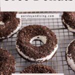Oreo covered chocolate donuts on a rack.