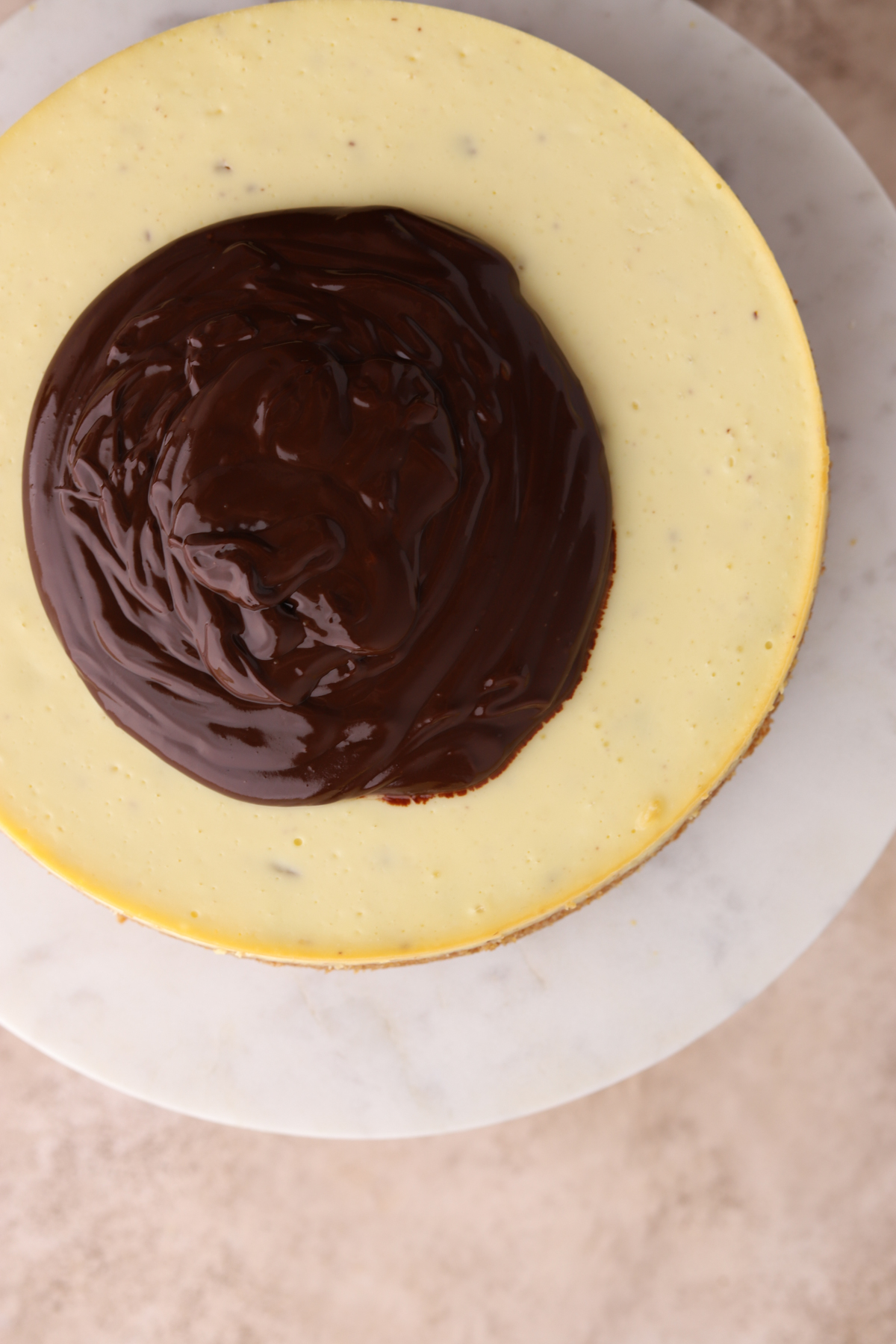 A cheesecake with chocolate ganache on top.