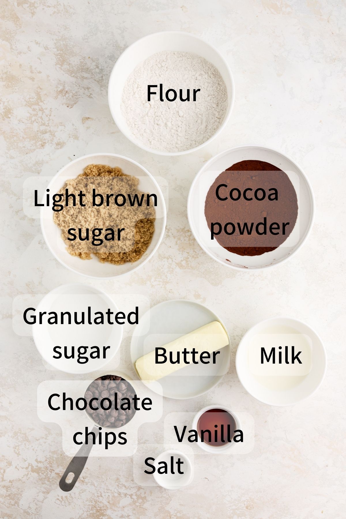 Labeled ingredients needed to make brownie batter laid out on a table. 